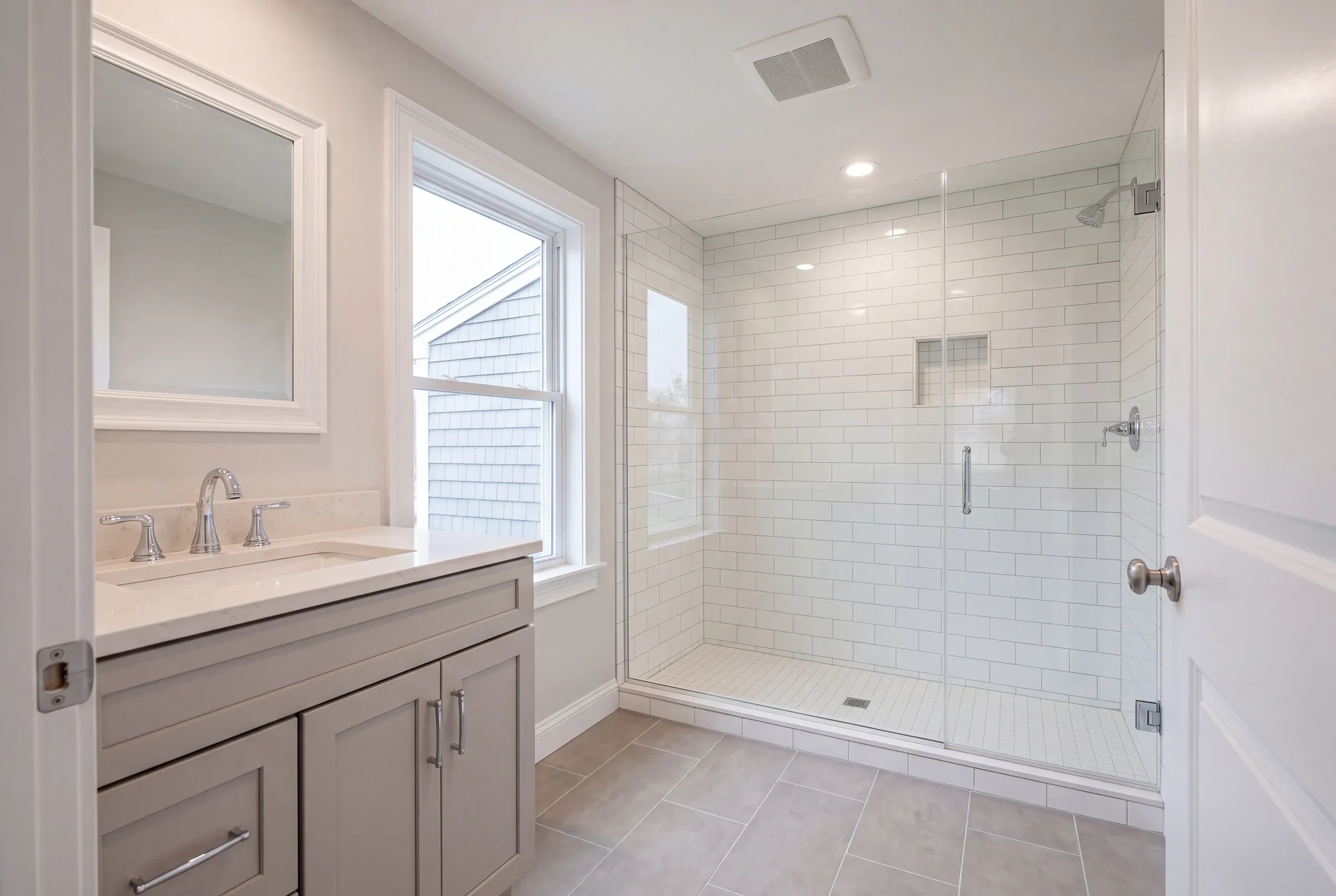Finished Augusta bathroom with the vanity and tiled shower in view