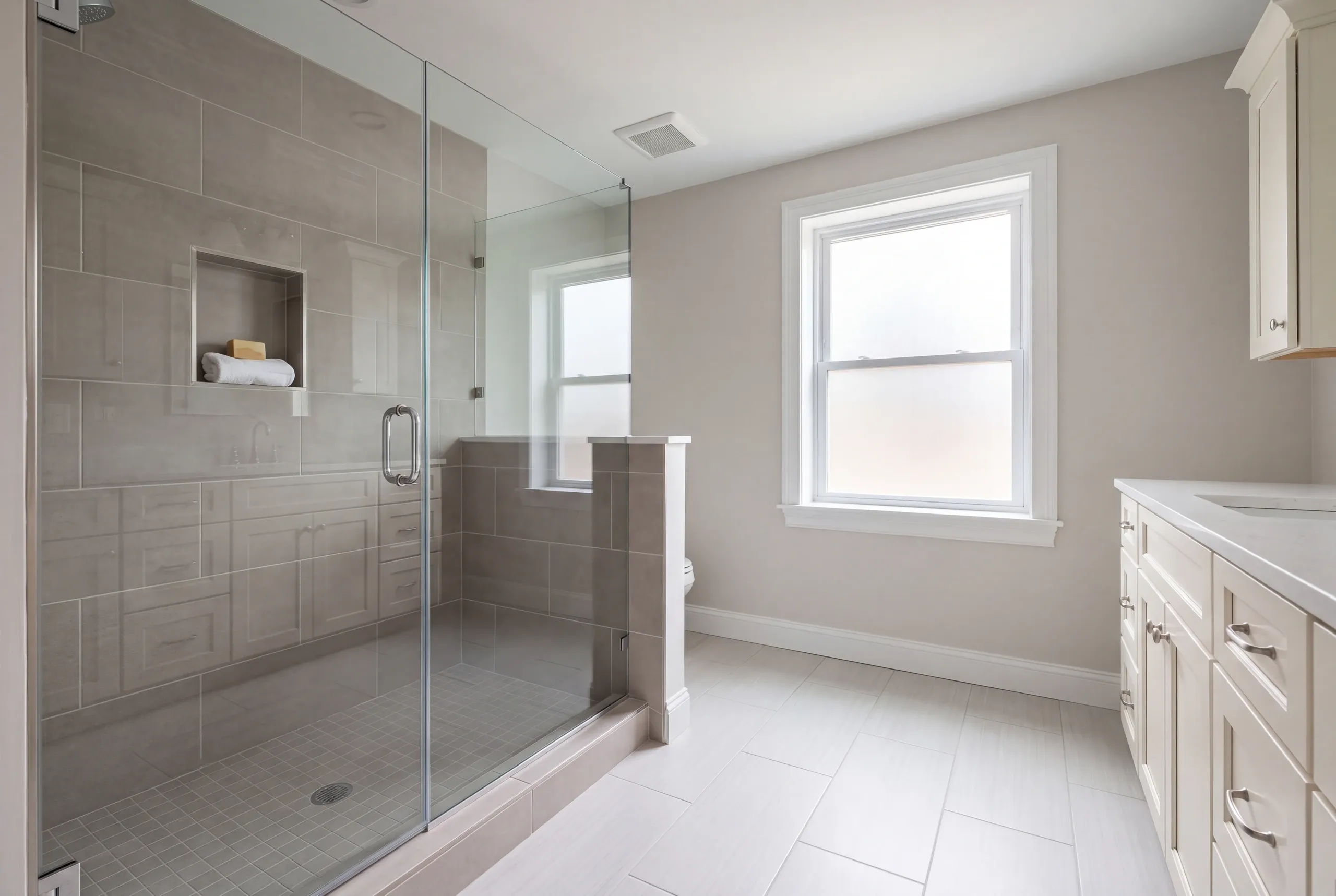 Newman Homes estimator inspecting a Gardiner bathroom floor before quoting