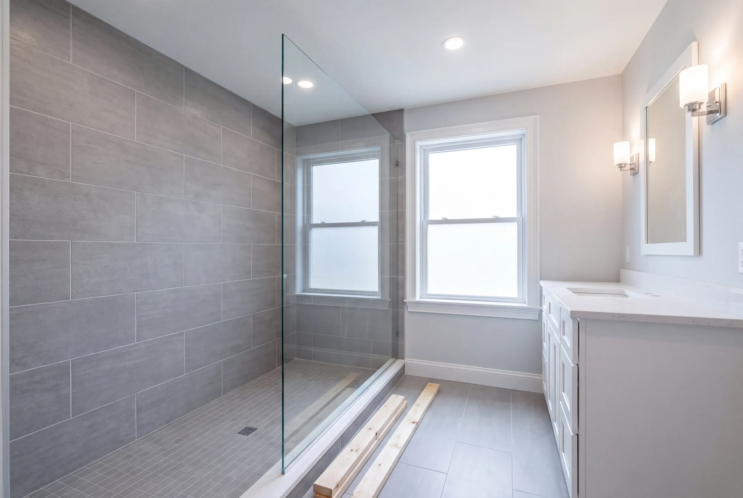 Tiled shower with glass being built in a renovated Maine bathroom