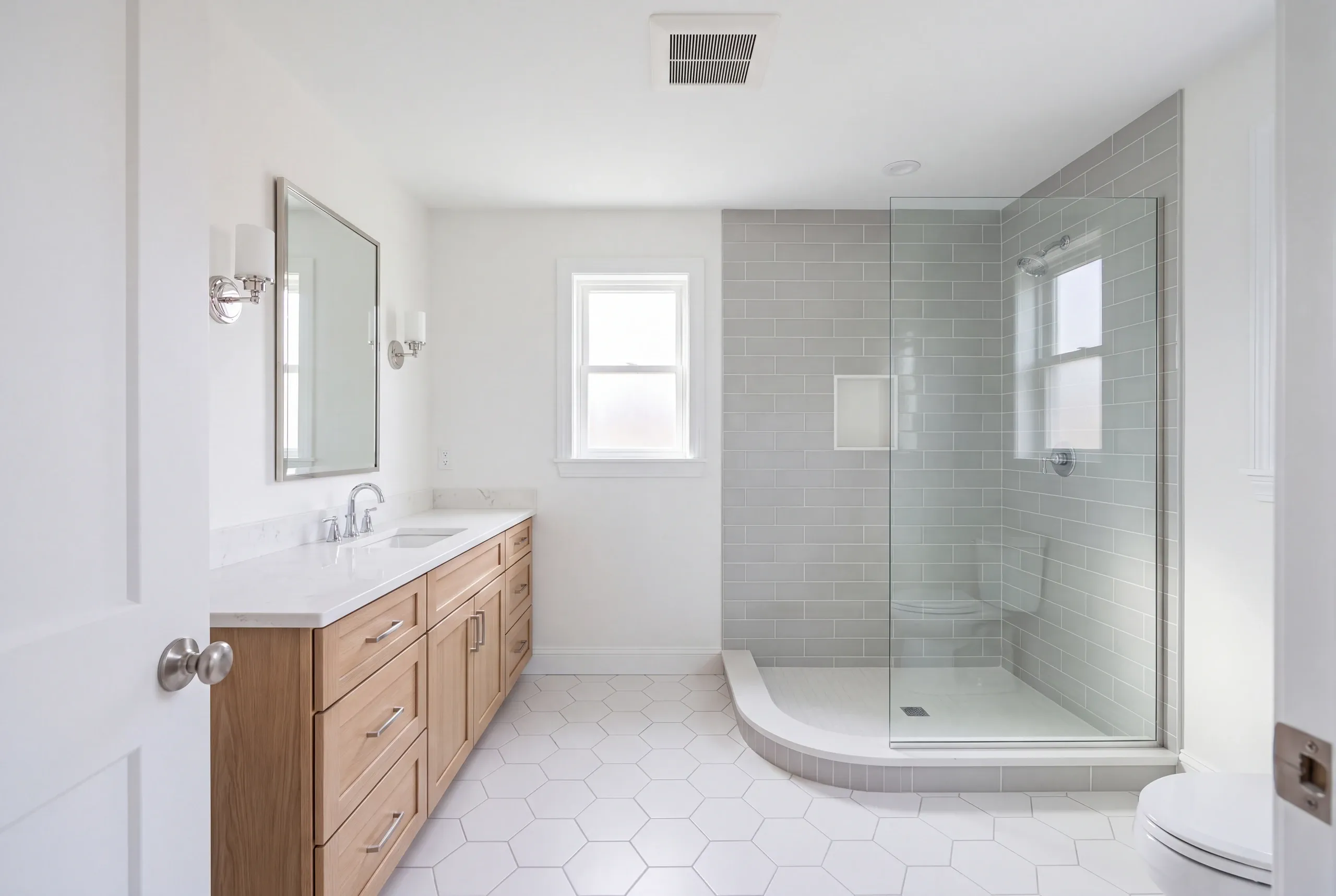 Finished Vassalboro bathroom with the vanity and tiled shower in view