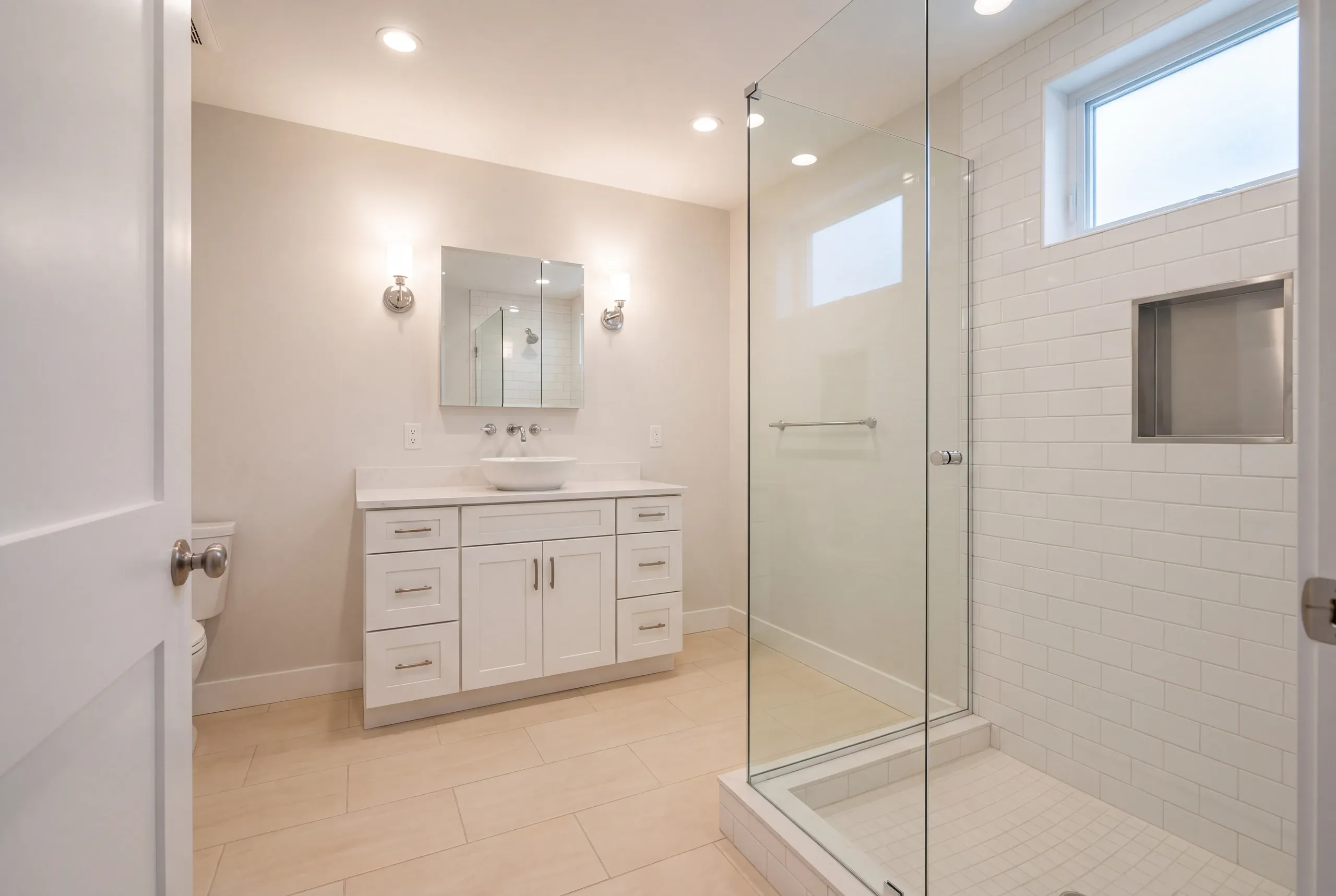 Finished Waterville bathroom with the vanity and tiled shower in view