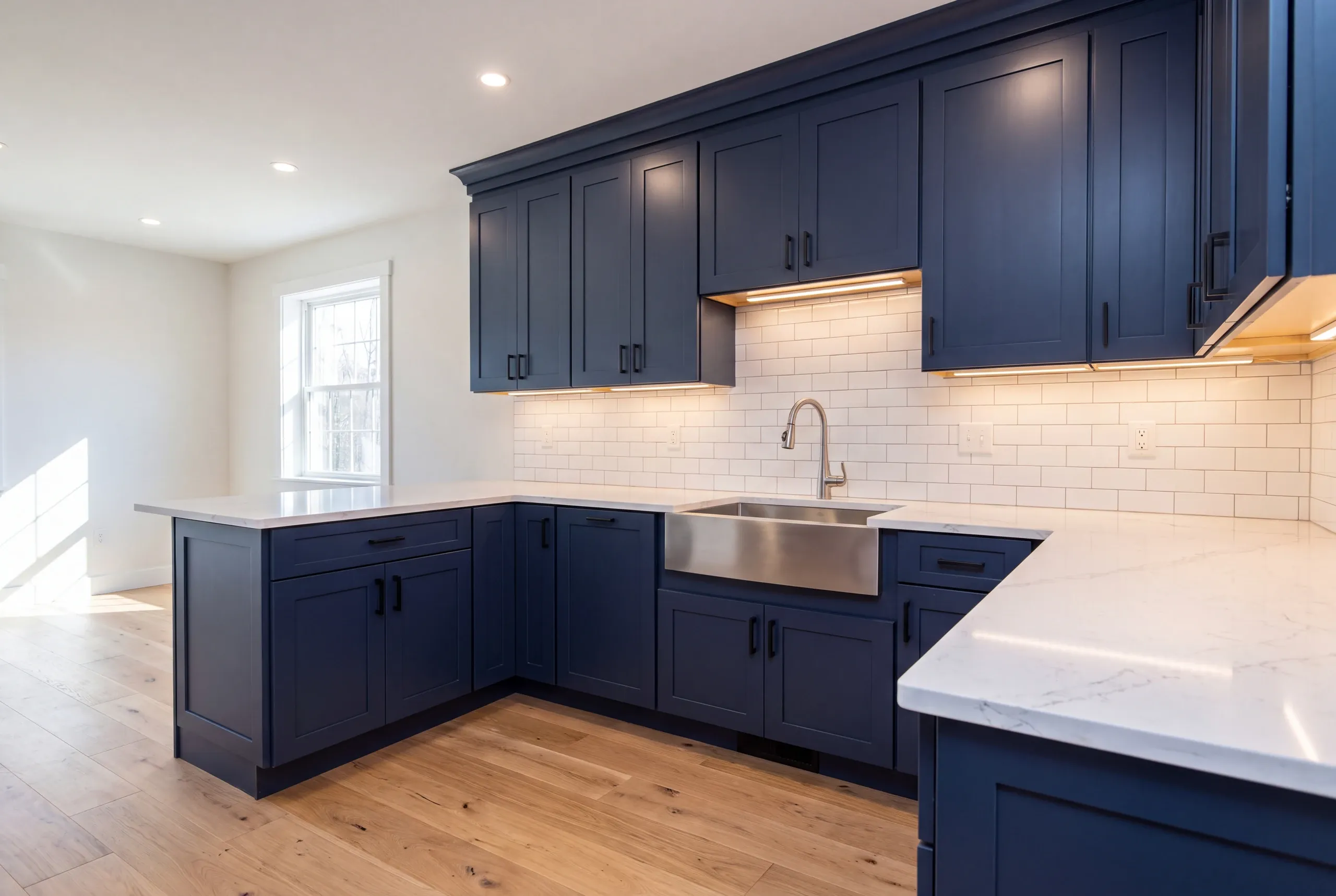 Builder reviewing a kitchen layout with homeowners in Sidney, Maine