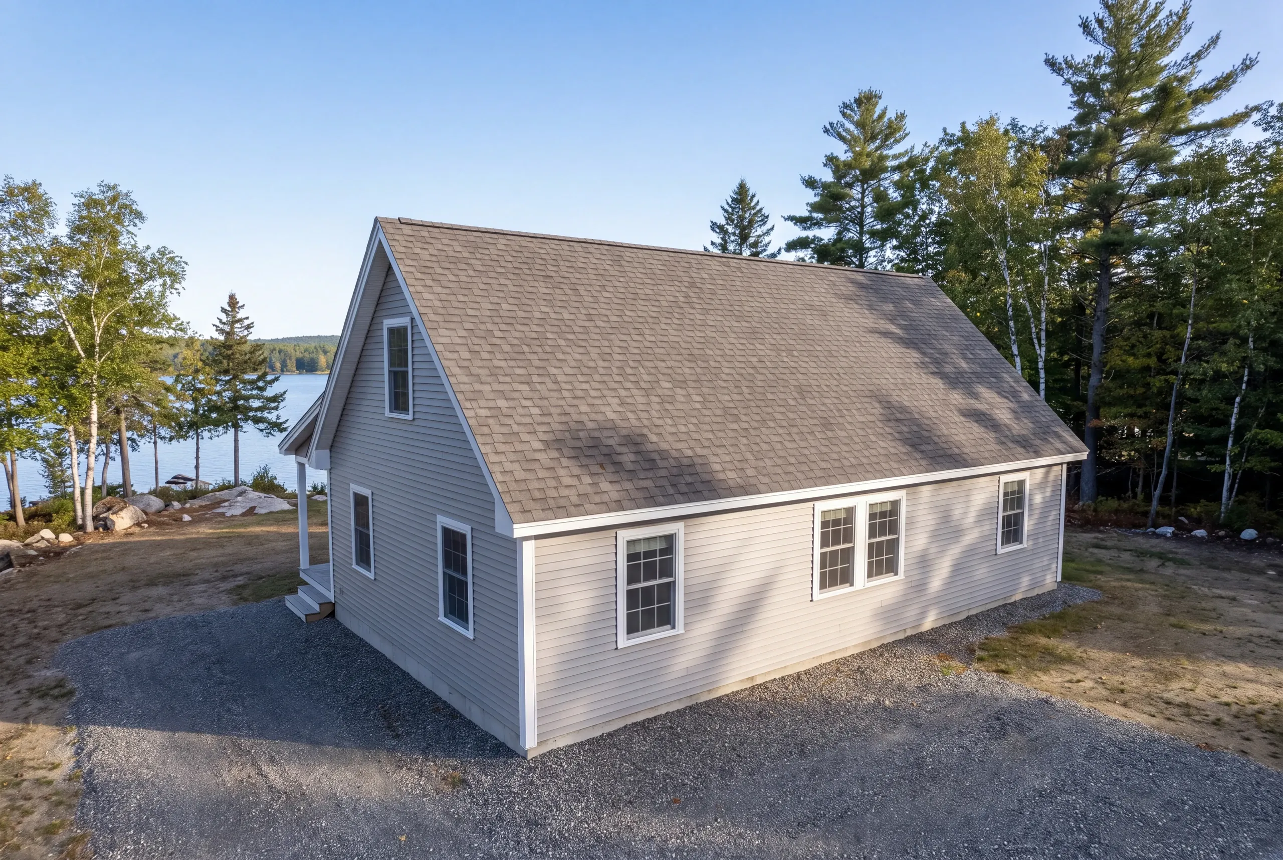 Crew hand-carrying shingle bundles to a Belgrade lakefront house