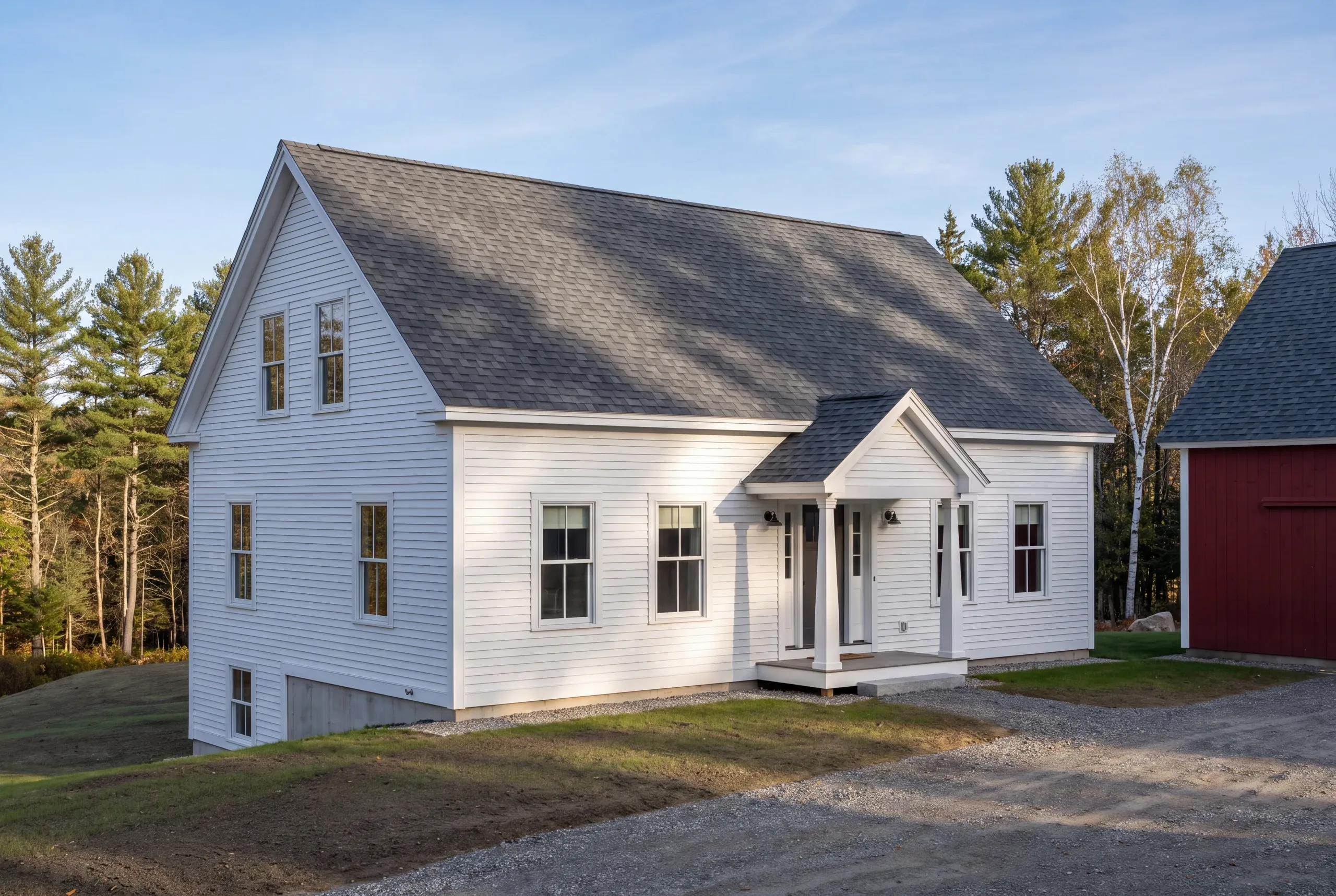 Roofing contractor Fairfield, ME working on a farmhouse and barn roof