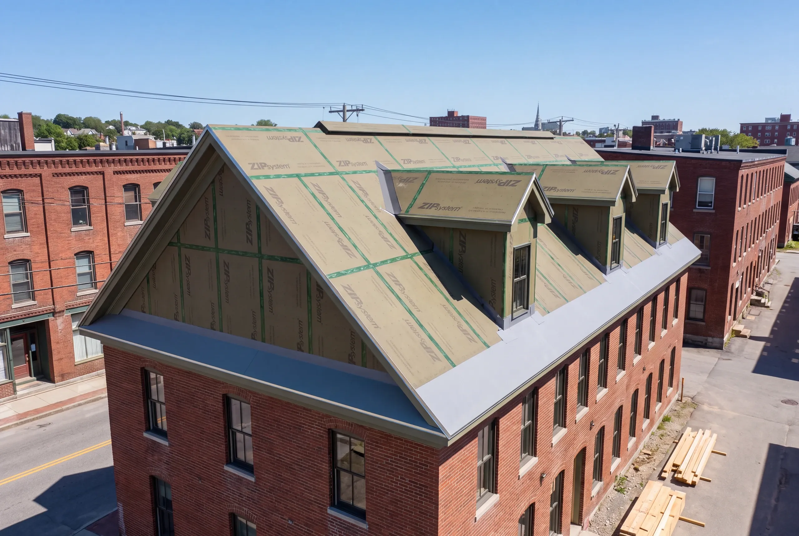 Three-story mill-era multi-family roof being replaced in Lewiston