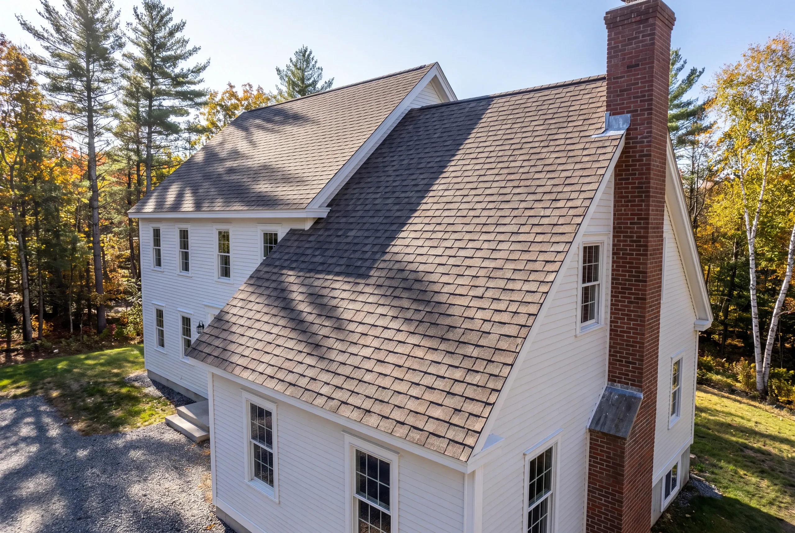 Roofing contractor Mt. Vernon, ME working on a hillside home roof