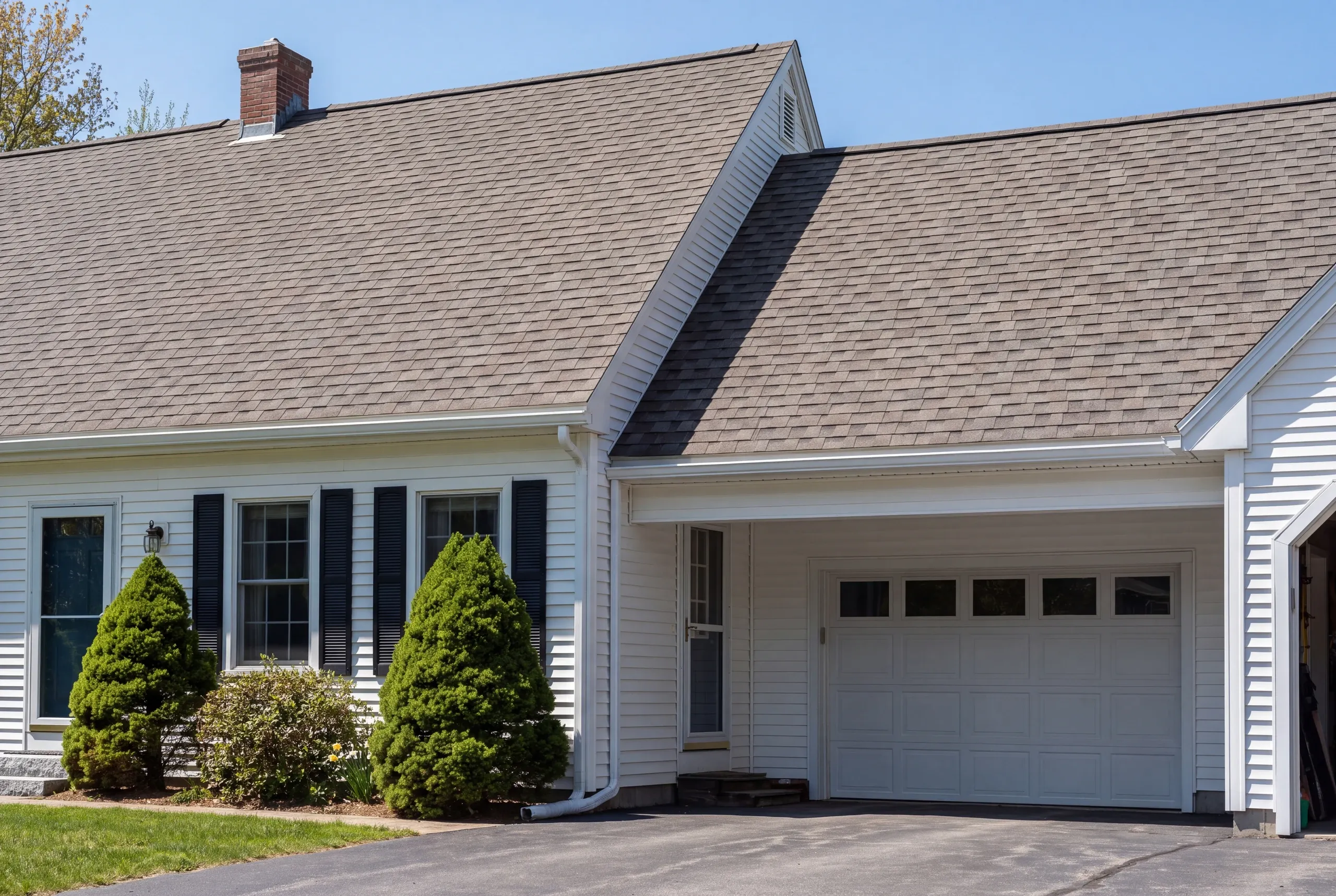 Finished roof, eaves and new gutter line on a Vassalboro home seen from the driveway