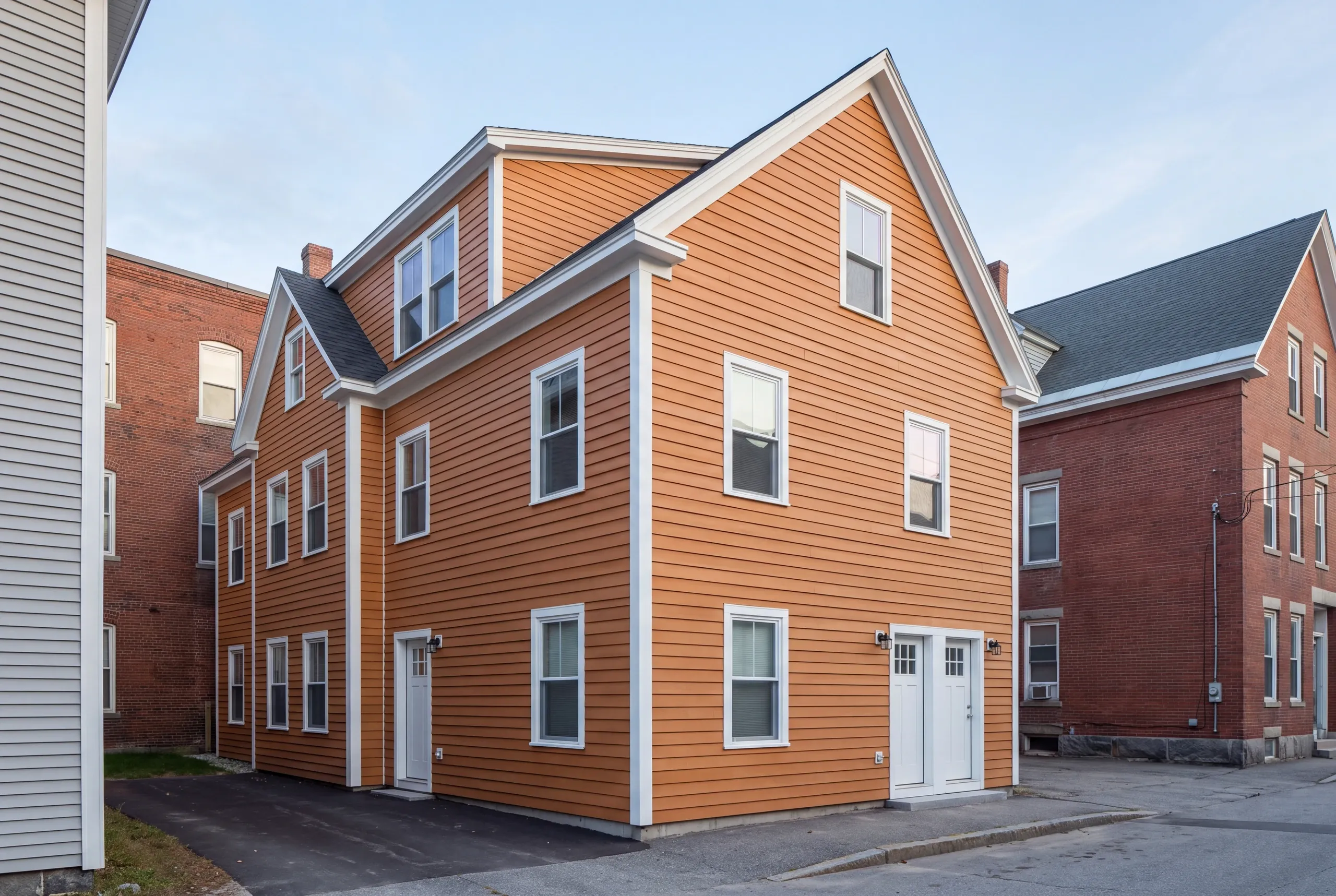 Siding contractor Lewiston, ME setting lead-safe containment on a multi-family